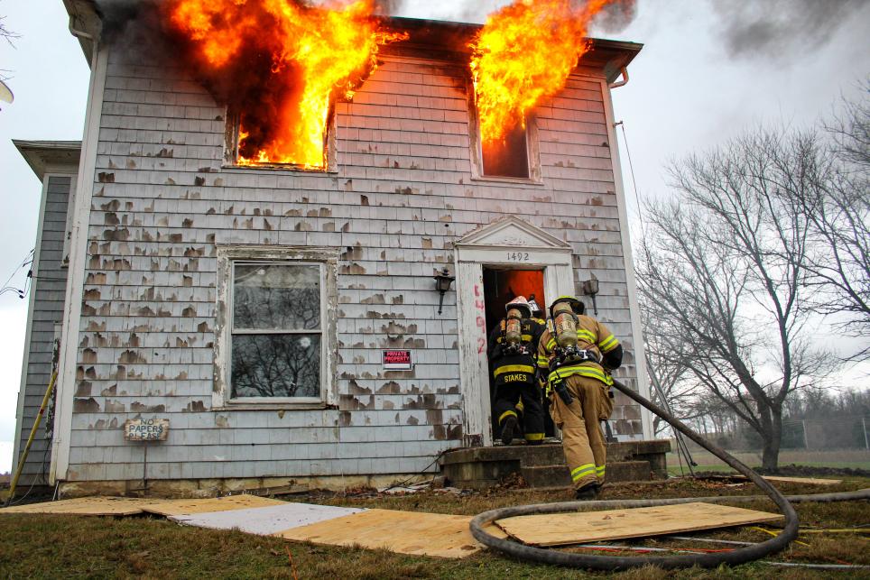 firefighters entering a house on fire 