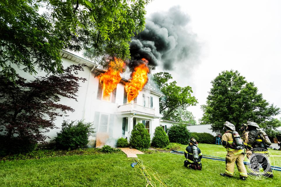 Firefighters facing a house on fire