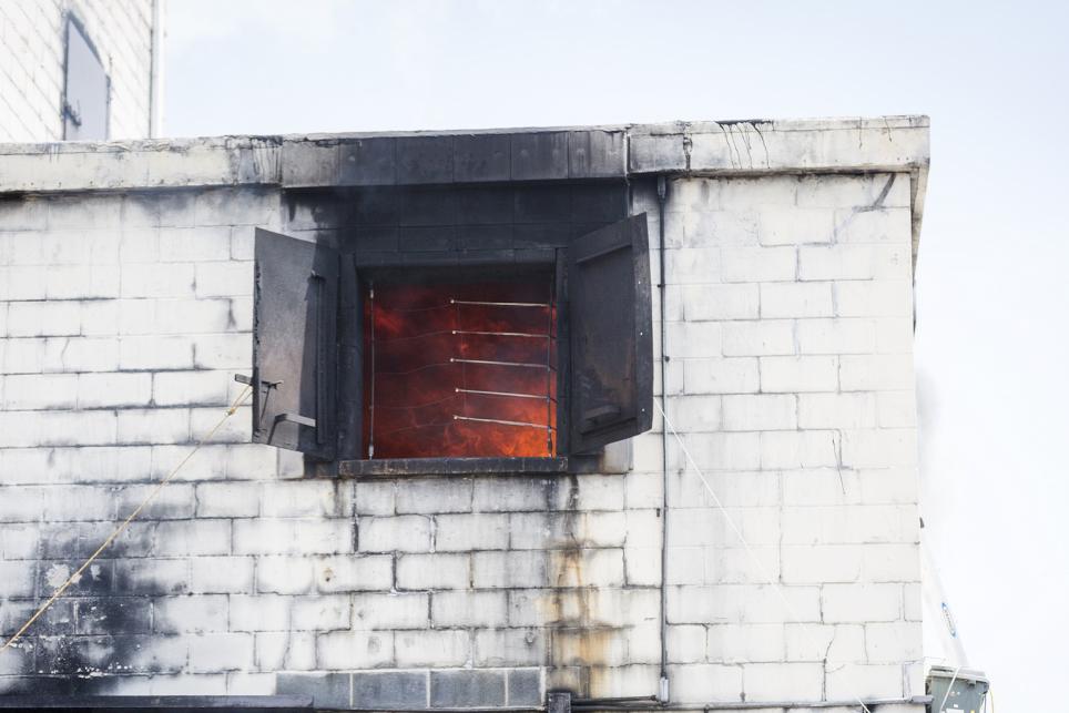 Concrete structure with fire showing through a window 