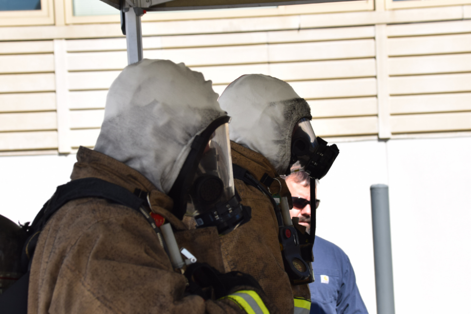 firefighters wearing protective gear and white hoods