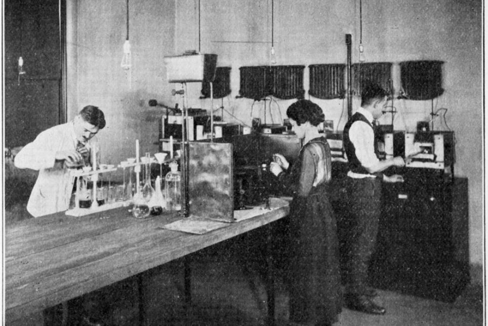 Louise Logie at work in the Chemical Department, 1920. She is conducting a test to determine the percentage of sulfur in a rubber sample.