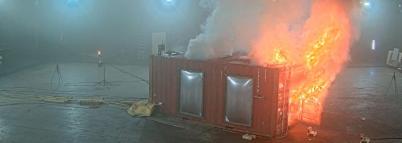 small building on fire inside of a large lab
