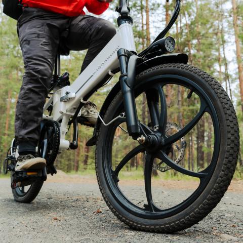 Male riding e-bike in wooded area