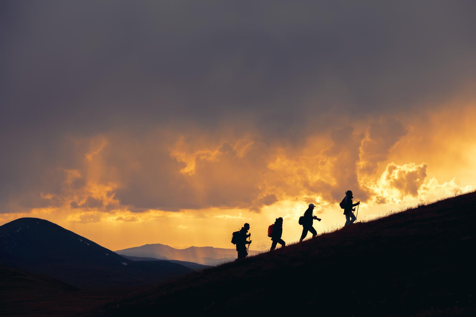 firefighters climbing a mountain with fire in the backgroundd