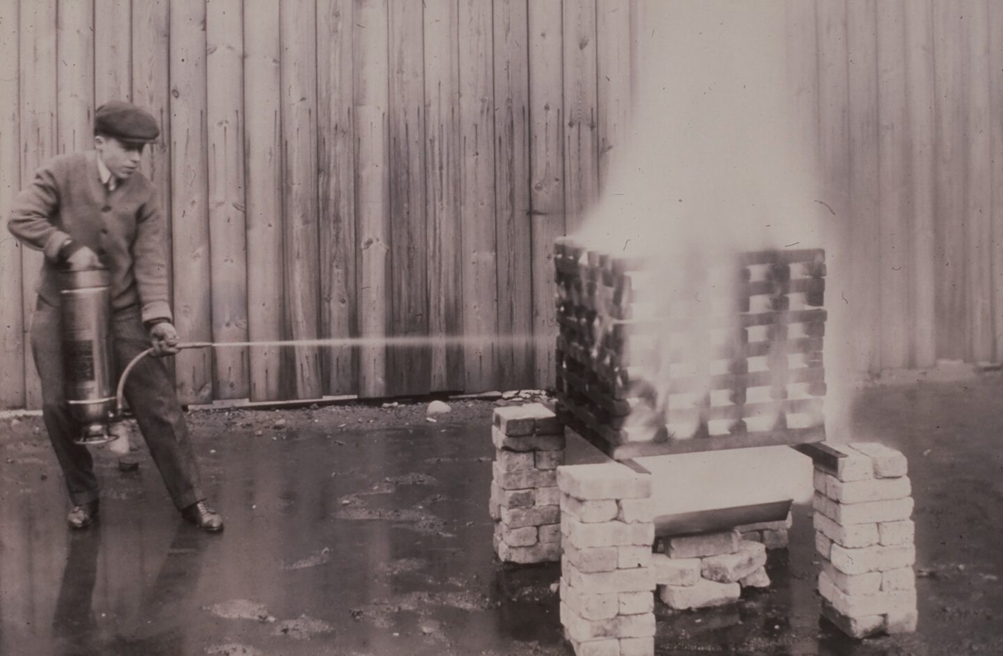 A soda acid fire extinguisher undergoing testing at Underwriters Laboratories, circa 1910s. These extinguishers were the first UL-labeled devices.