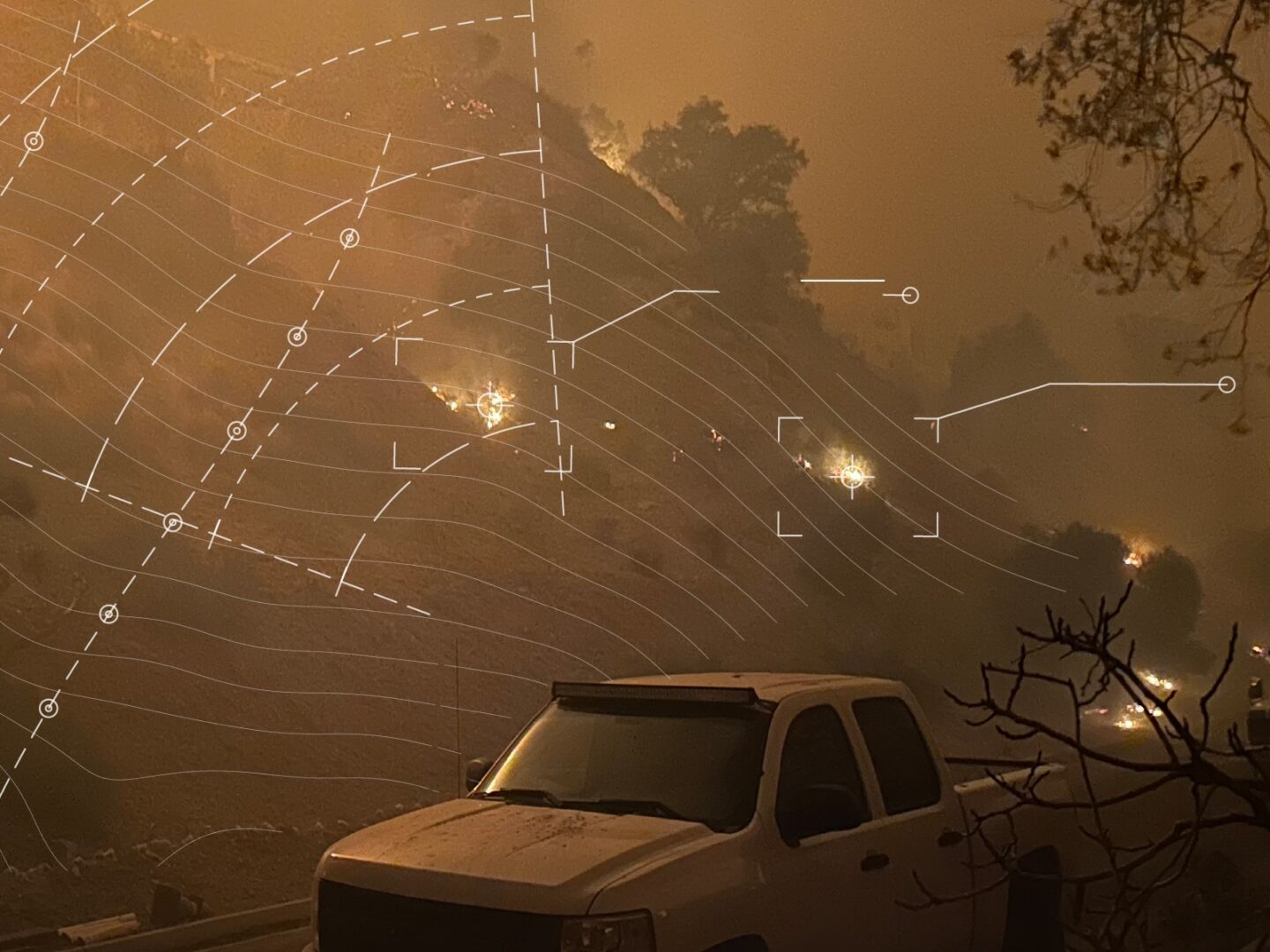 Wildfire spreading across a hillside at night with white contour lines and markers overlaid on top representing wildfire risk modeling.